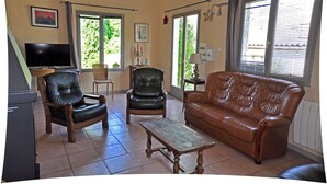 A living room with a brown leather sofa, two leather chairs, a wooden coffee table, a television, and a window with curtains. - Promotions to seize: Beautiful artist cottage, private pool, exceptional view (Peyrefitte-sur-l'Hers)