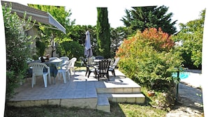 An outdoor patio with a table and chairs, surrounded by greenery and a swimming pool. - Promotions to seize: Beautiful artist cottage, private pool, exceptional view (Peyrefitte-sur-l'Hers)
