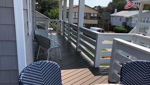 Un patio techado al aire libre con una mesa redonda y cuatro sillas estampadas.