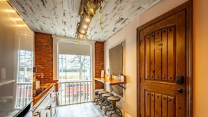Une cuisine moderne dotée d’une grande fenêtre, d’un plancher en bois et d’un plafond au style rustique.