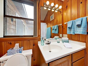 A bathroom with wooden paneling, a white sink, a mirror, and multiple towels. - Ocean Front! On the sand!! Stunning 5 BR house on Atlantic Ave, Wells Beach!!! (Wells)