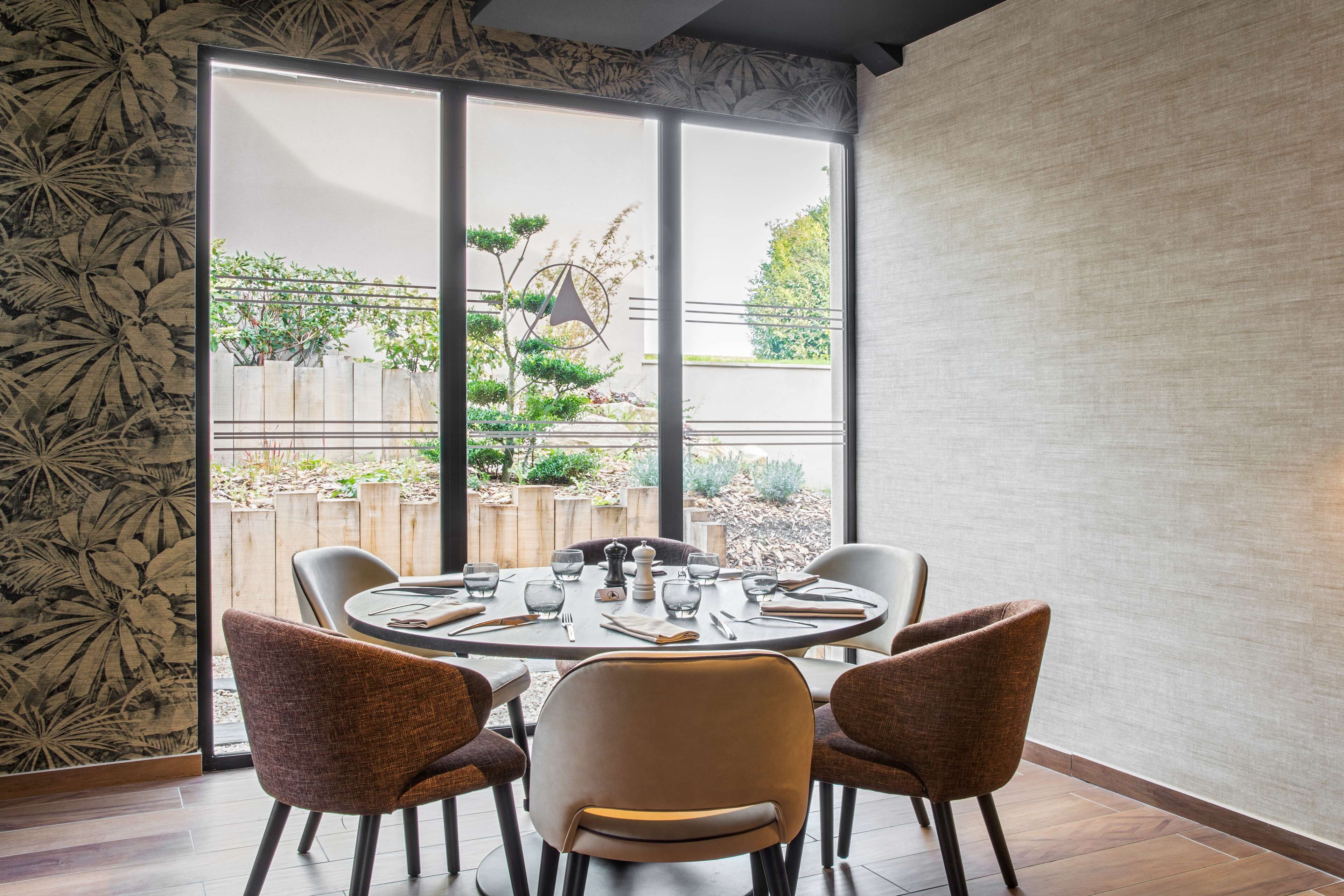A dining area with a round table set for four, surrounded by chairs.