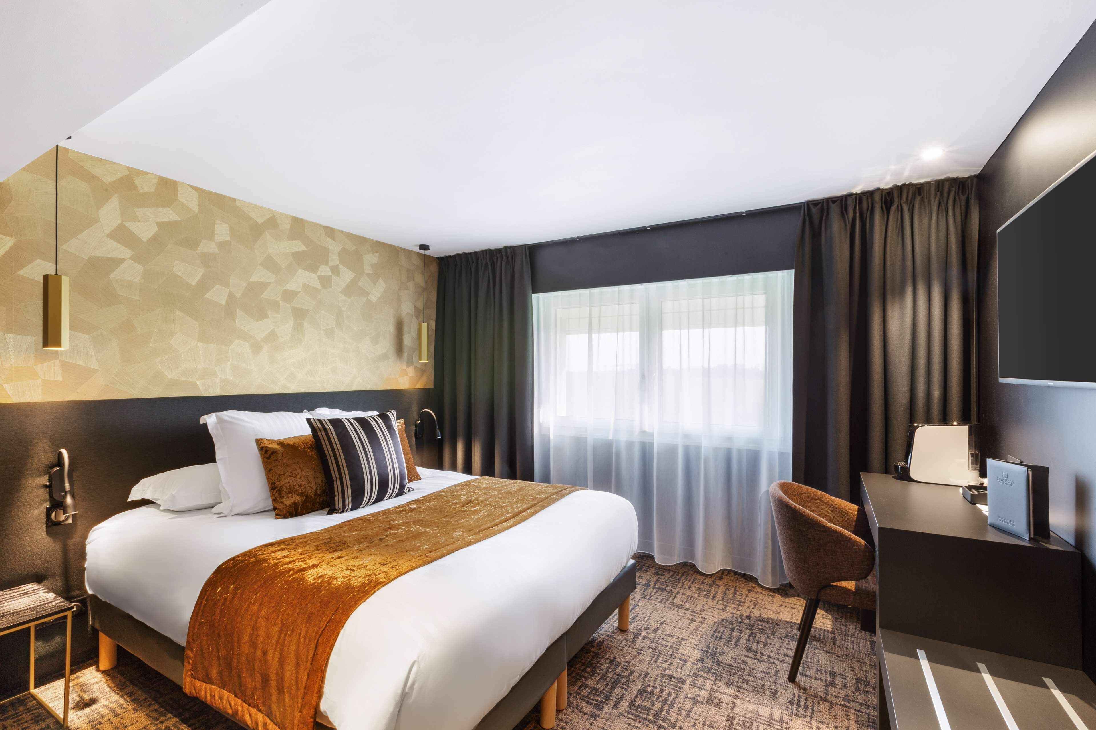 A modern hotel room with a large bed, a desk, and a chair.