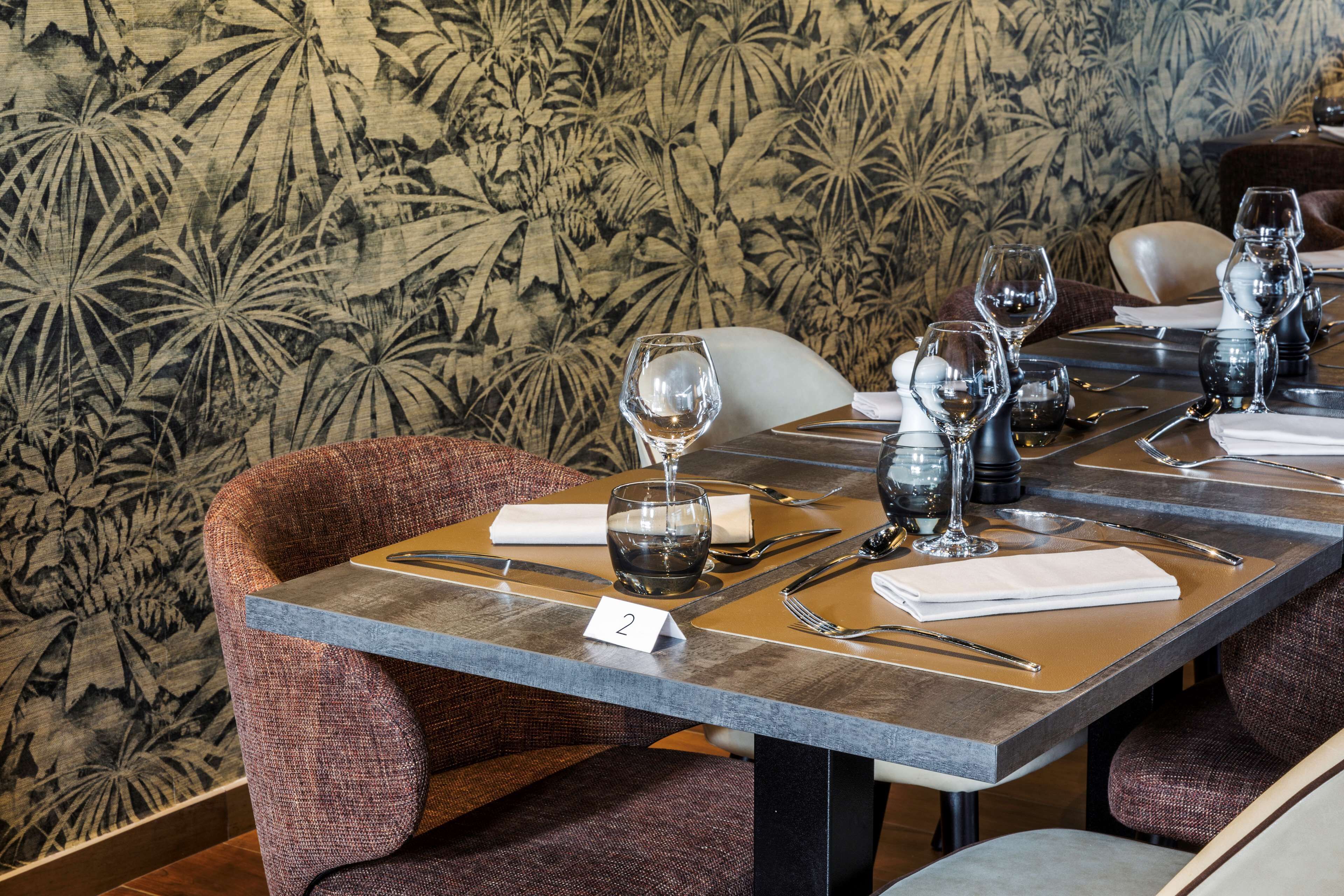 A dining table set with wine glasses, cutlery, and a number tag.