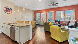 Amplia sala de estar con cocina, mesa de comedor y disposición de asientos.