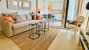 A modern living room with a sofa, coffee table, and dining area. - Newly renovated dream apartment with all amenities (Torrox Costa)