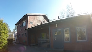 Un edificio a due piani con un portico coperto e un garage.