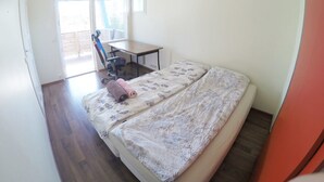 Una camera da letto con un letto, una scrivania e una sedia.