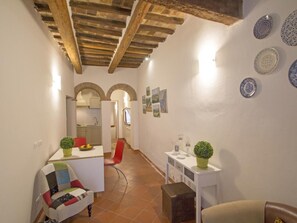 Cozy living space with a seating area and kitchenette, featuring a sofa and framed pictures.