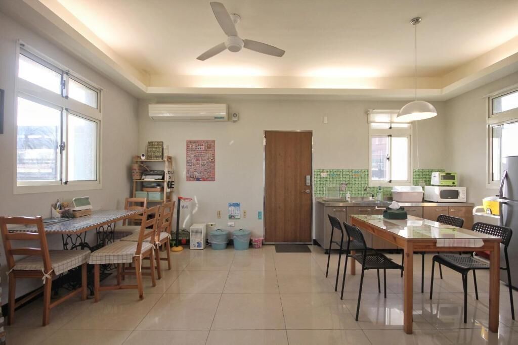 A spacious kitchen with a dining area, a ceiling fan, and a view through the window.
