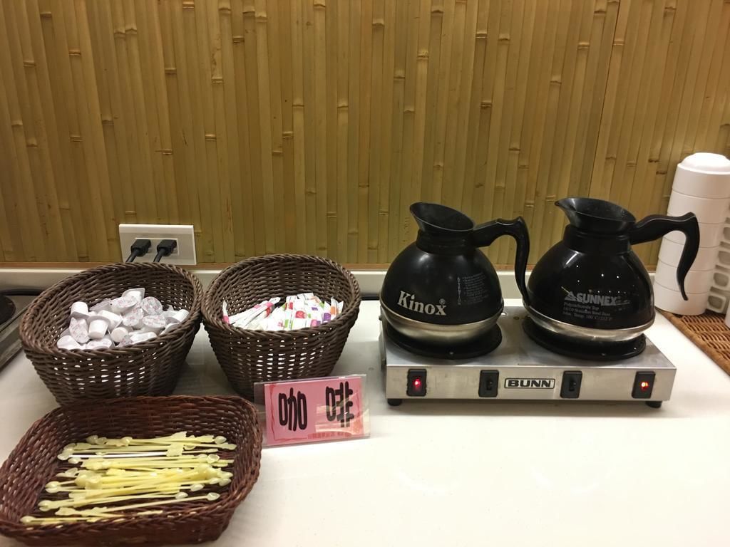 Een aanrecht met manden vol lekkernijen, twee koffiezetapparaten en een weegschaal.