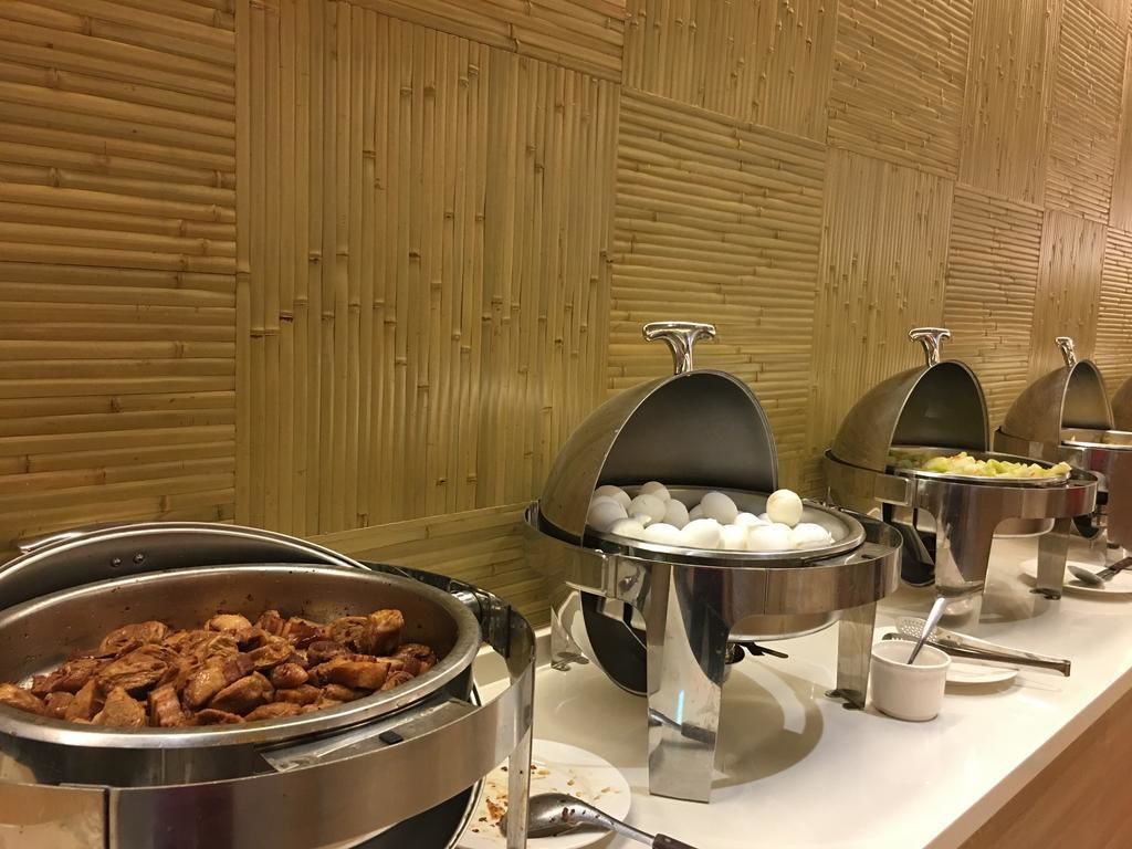 A buffet with various food items including meat, eggs, and vegetables.