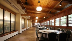 A long corridor with round tables and chairs, large windows, and wooden ceilings. - Ku Kuan Hotspring Hotel (Taichung)