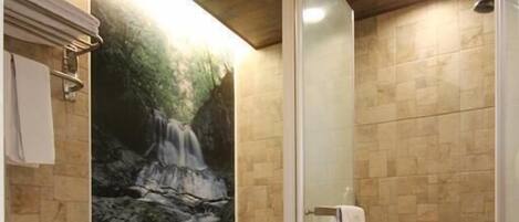 A bathroom with a shower, toilet, and a large sink.