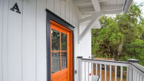 A white building with a wooden door and a black frame.