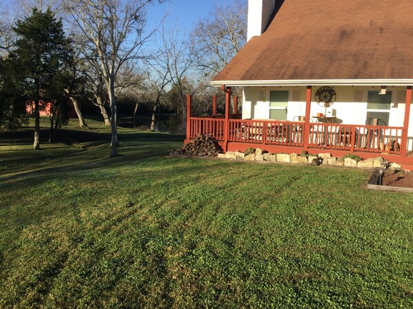A house with a red porch, a well-maintained lawn, and a brick chimney.