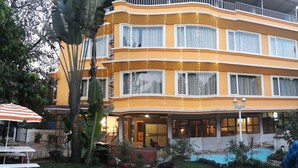 A multi-story hotel with a curved facade, large windows, and a swimming pool in the courtyard. - Lake View Resort (Mawal)