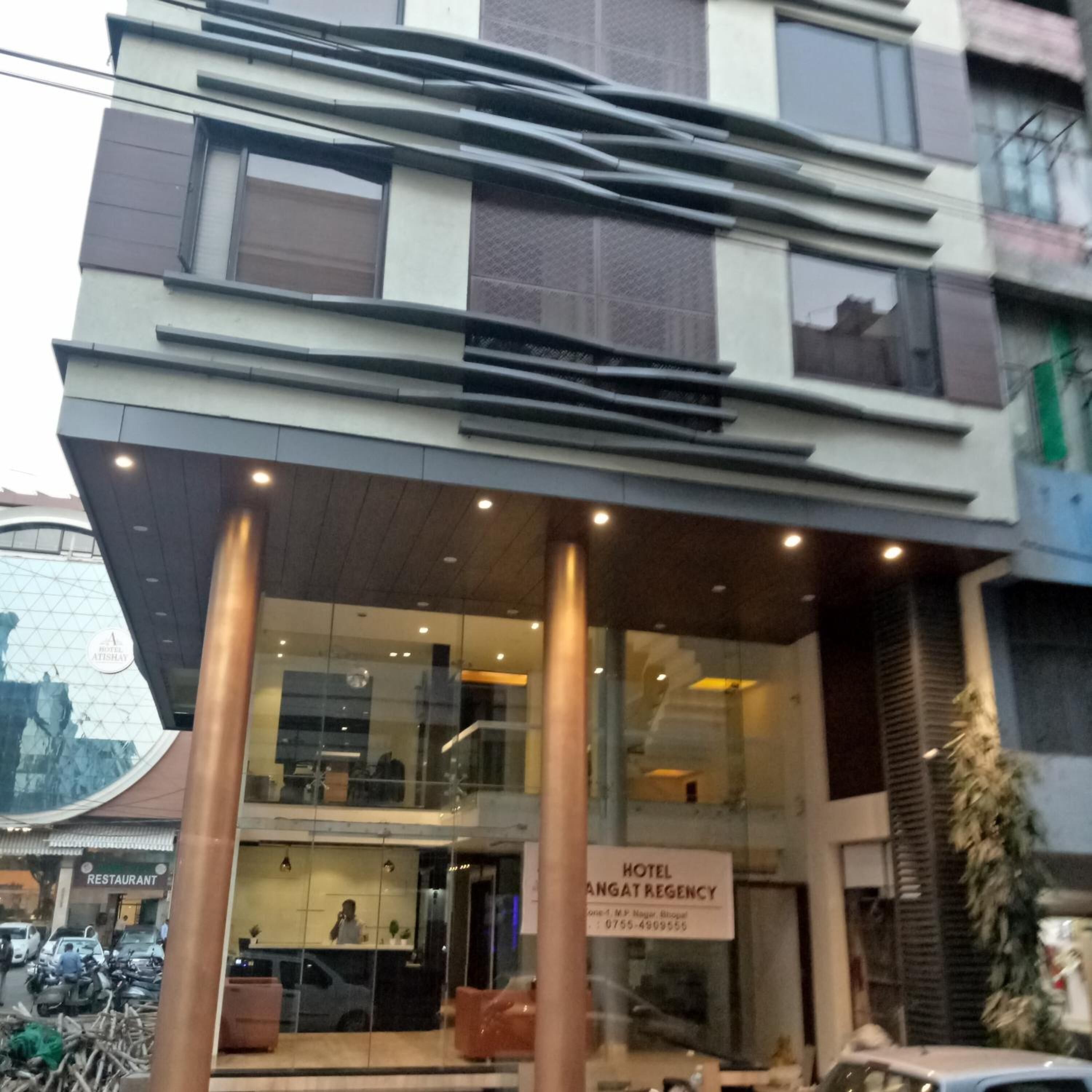 A hotel with a modern facade, a visible entrance, and a sign indicating it is a hotel.