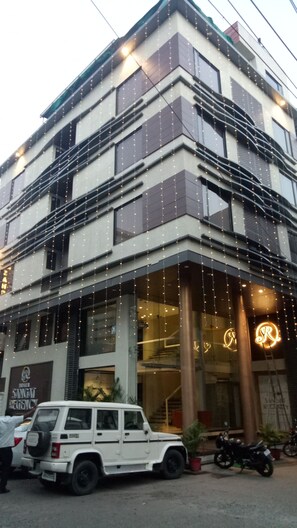 A multi-story building with a modern architectural design, featuring large windows and a prominent entrance with decorative lighting. - Hotel Sangat Regency (Bhopal)
