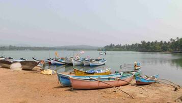A lakeside scene with several boats docked along the shore.