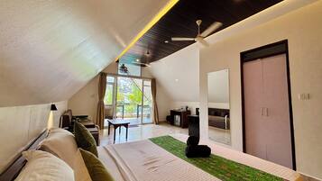 Una habitación de hotel moderna con cama, escritorio, silla, sofá, espejo y ventilador de techo.