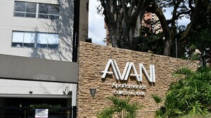 En byggnad med en fasad av sten och en skylt med texten: "AVANI Apartamentos Calle 27 No. 41 86".