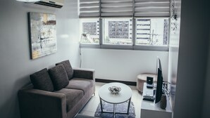 Un saló modern amb un sofà, una taula de centre i un televisor sobre un moble.