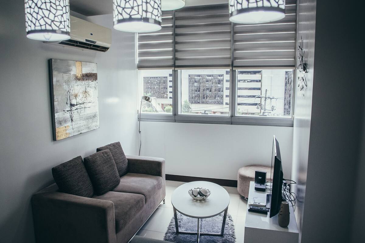 A modern living room with a sofa, coffee table, and a TV on a stand.