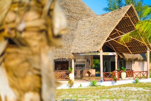 A thatched-roof building with a sign reading "PAJE PALMS BEI RESORT". - VRclub - Paje Palms Beach Resort (Paje)