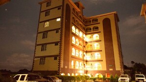 Un hotel de varios pisos con un patio central, con balcones y ventanas amplias.