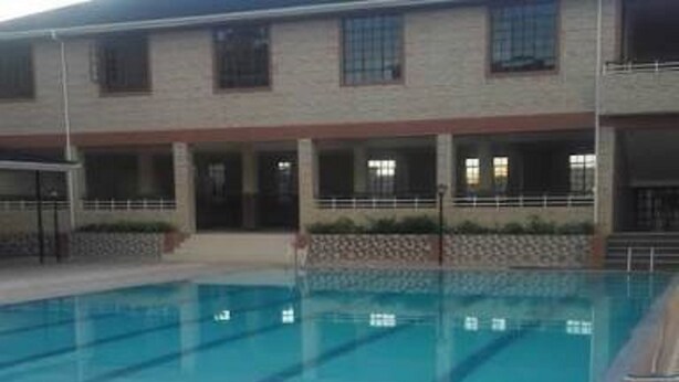 Una piscina rectangular con agua cristalina y un bordeado de baldosas.