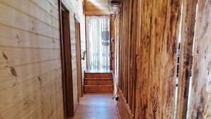 Un pasillo de madera con una escalera que lleva a una habitación.