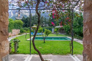 Un espace piscine offrant une vue dégagée sur le paysage environnant, notamment sur les arbres et un mur de pierre.