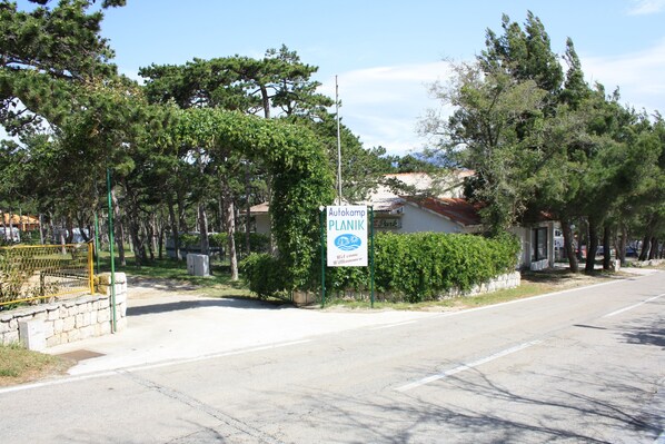 A street view with a sign for 'Autokamp Planik' indicating a camping area.