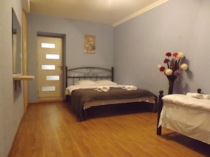 Cozy retreat with a comfortable bed, a small table, and a vase of flowers.
