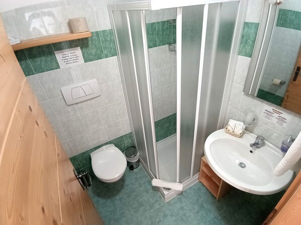 A bathroom with a shower, toilet, and sink.