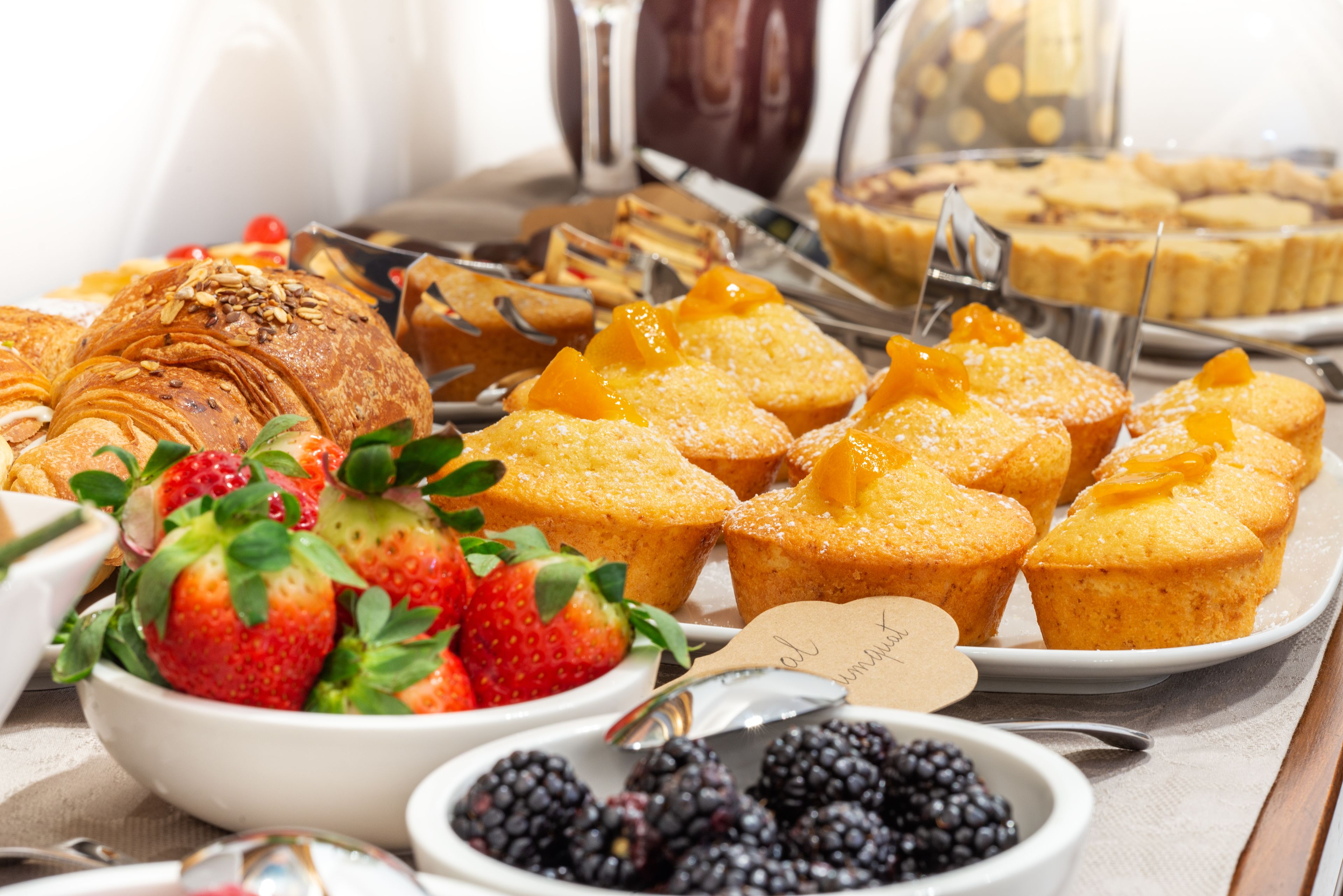 A variety of pastries and fruits on a tray.