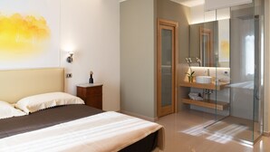 Un dormitorio moderno con cama, mesita de noche y un espejo grande.