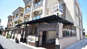 A multi-story building with a covered entrance area, signage in a foreign language, and a bicycle parked outside. - Kai Feng B&B (Taitung)