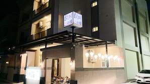 A multi-story building with a covered entrance, a bicycle rental service, and a car parked outside. - Kai Feng B&B (Taitung)