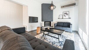 Una sala de estar moderna con un sofá gris, una mesa de centro y una chimenea.