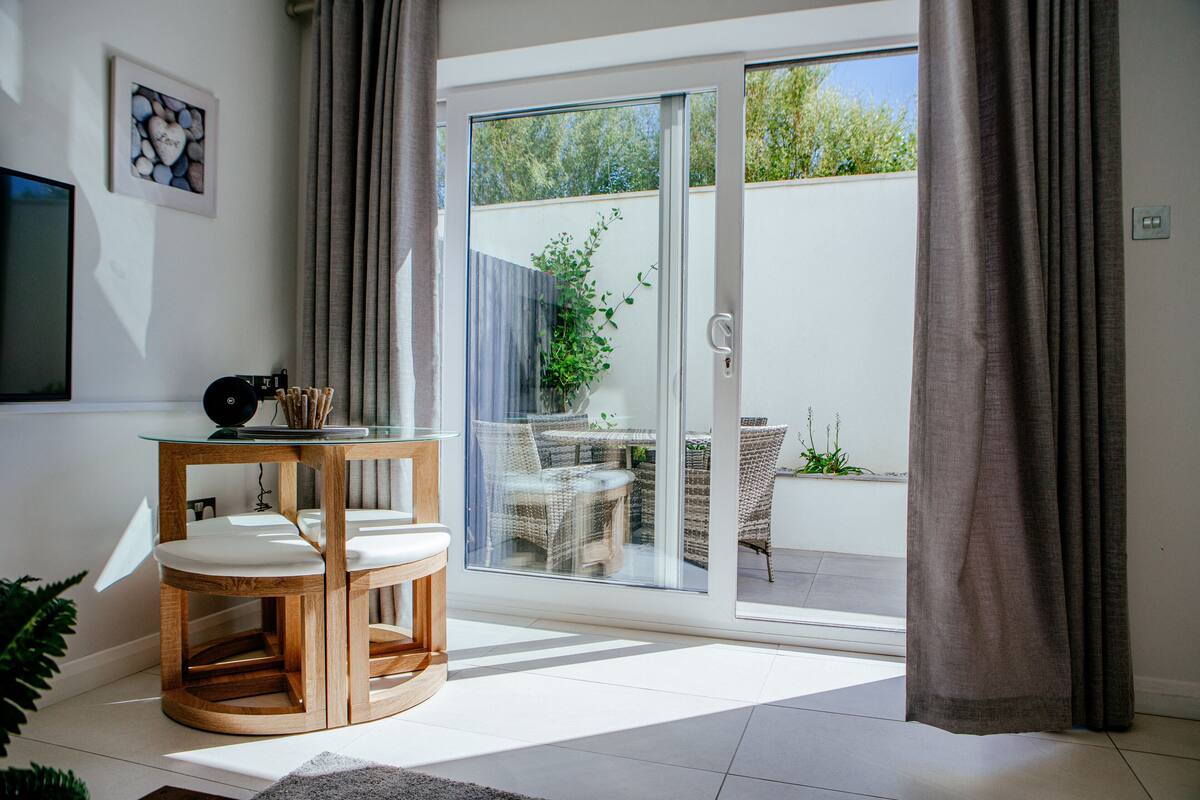 A modern living room with a glass door leading to a patio.