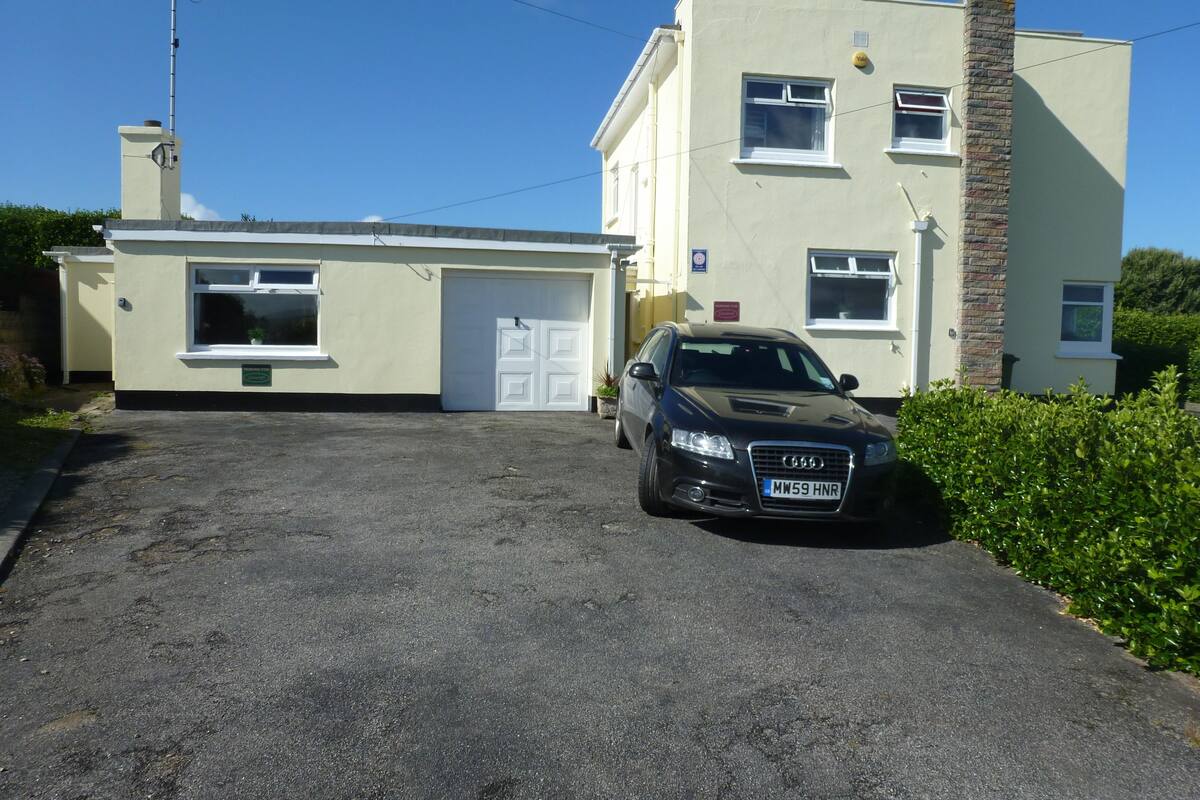 A two-story building with a garage and a parked car.