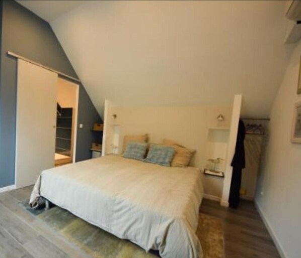 Un dormitorio con cama, mesita de noche y armario.