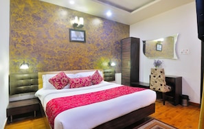 Relax in a stylishly appointed room with a large bed, wooden nightstand, and a decorative throw.
