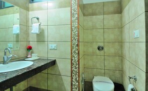 Bathroom features a white sink, granite countertop, and a toilet with a privacy partition.