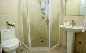 Une salle de bain comprenant des toilettes, un espace douche et un lavabo.