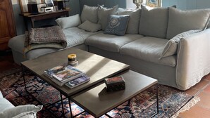 Una sala de estar con sofá, mesa de centro y alfombra estampada.