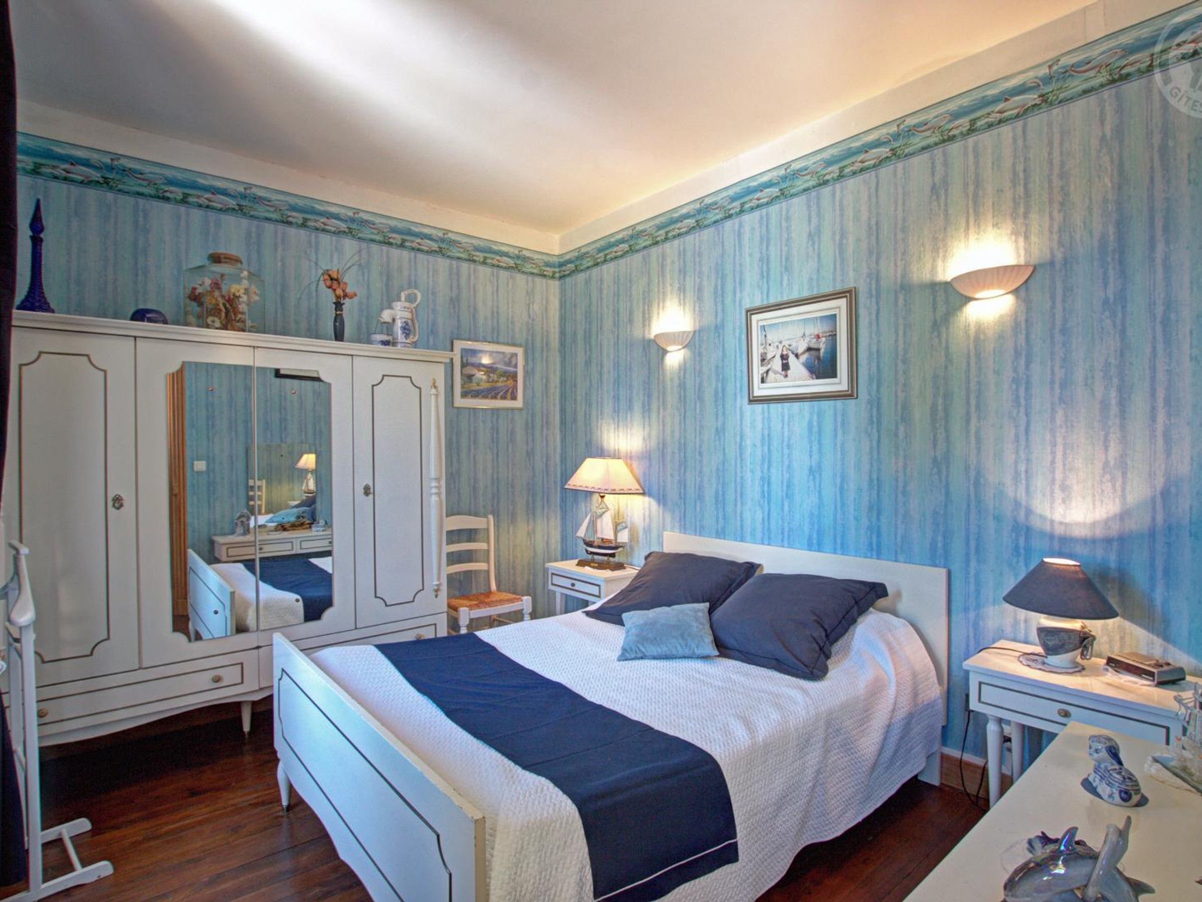 Een slaapkamer met een bed, een dressoir en nachtkastjes.