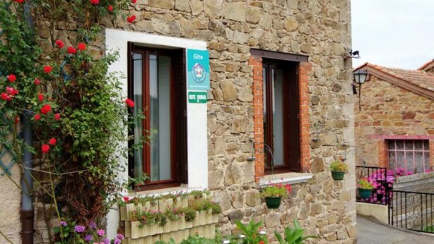 A stone building with a sign indicating it is a Gîte rural accommodation. - Charming Cottage with Terrace and Garden, Pets Welcome (Bussières)